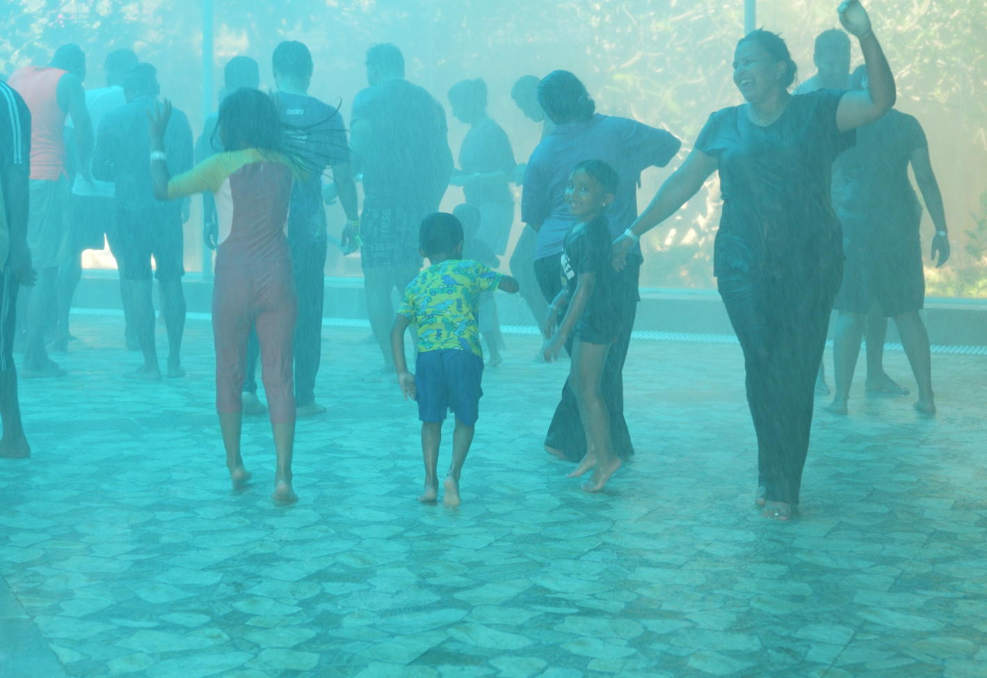 Kids with family enjoying rain dance at club cabana during mid term school holidays